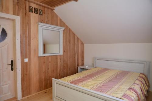 a small bedroom with a bed and a mirror at Котедж Соняшник in Verkhovyna