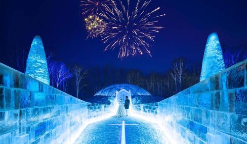 a person is standing on a bridge with blue lights at Santari in Shintoku