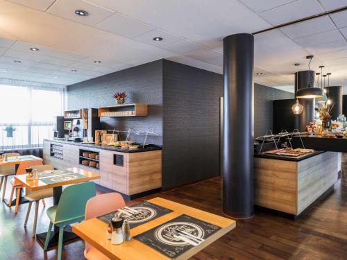 a kitchen and dining room with tables and chairs at Mercure Hotel Berlin Zentrum Superior in Berlin