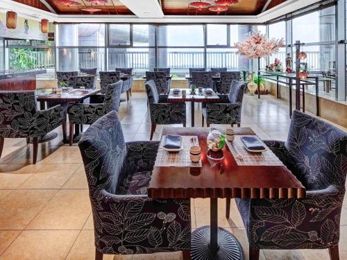 a dining room with tables and chairs in a restaurant at Oriental Ginza Hotel Shenzhen in Shenzhen