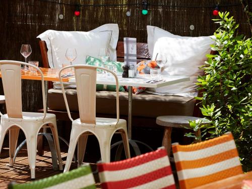a table with two chairs and a table with wine glasses at Mama Shelter Lyon in Lyon