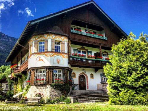 a house in the mountains with flowers on the balconies at Gästehaus Hohe Tannen in Garmisch-Partenkirchen