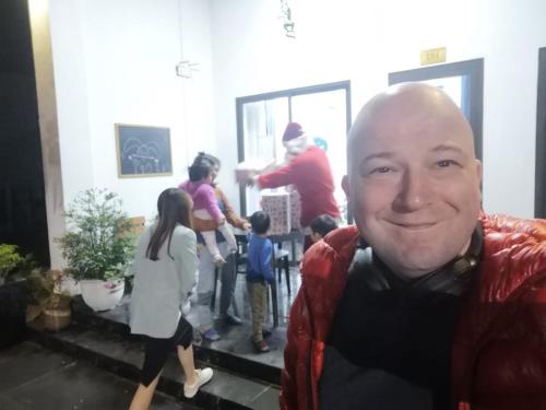 a man smiles at the camera with a group of people at Coto Center Homestay in Dao Co To