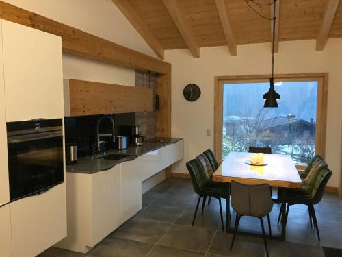 フィーホーフェンにあるChalet Glemmtal - Haus Bergblickのテーブルと椅子のあるキッチンとダイニングルーム