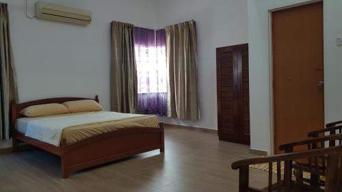 een slaapkamer met een bed en een raam bij D'Villa KP in Kuala Terengganu