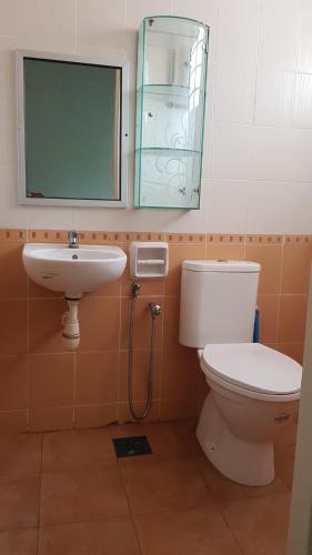 een badkamer met een toilet, een wastafel en een spiegel bij D'Villa KP in Kuala Terengganu