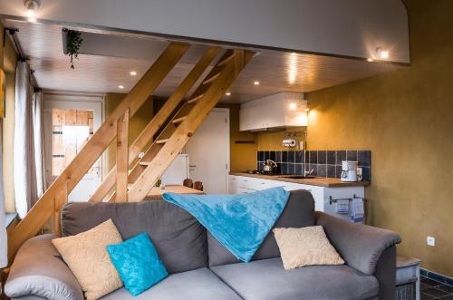 a living room with a couch with blue pillows at B&B Art.14 in Morkhoven