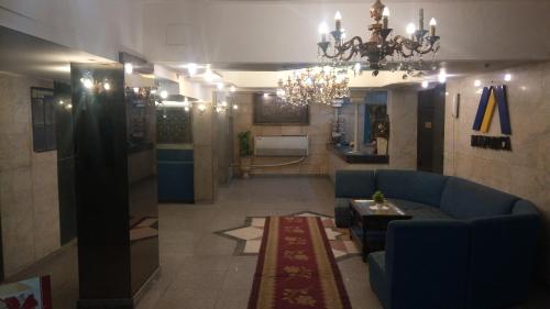 فندق مايوركا  في القاهرة: غرفة معيشة مع أريكة زرقاء وطاولة