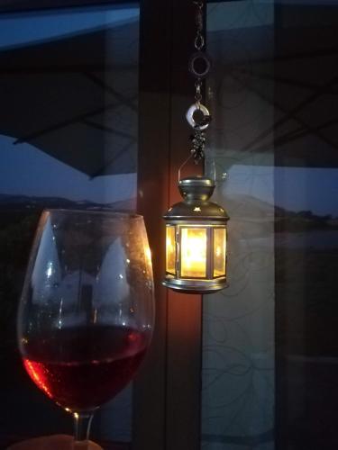 a glass of wine next to a candle and a glass of wine at Il Faggio 17 B&B in Artena