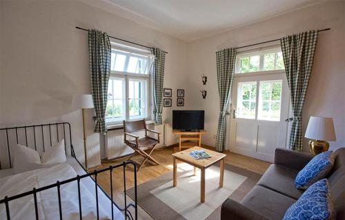 a living room with a couch and a tv at Gästehaus Hohe Tannen in Garmisch-Partenkirchen