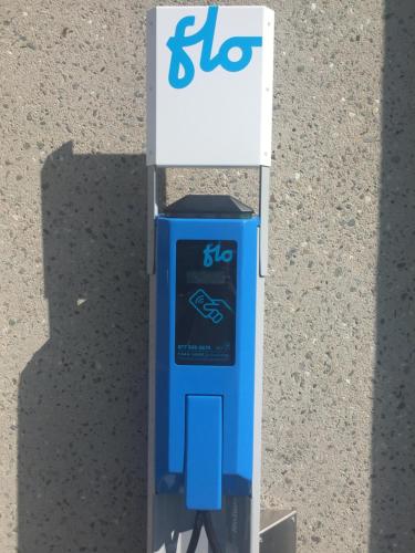 a blue and white gas pump next to a sign at La Saguenéenne - Hôtel et Centre de Congrès in Saguenay