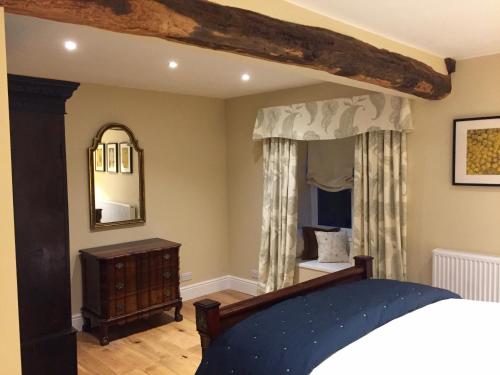 - une chambre avec un lit et un miroir dans l'établissement The Coach House, à Austwick