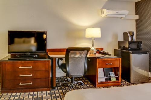 a hotel room with a desk and a television at La Saguenéenne - Hôtel et Centre de Congrès in Saguenay