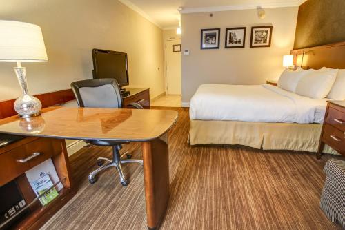 a hotel room with a bed and a desk at La Saguenéenne - Hôtel et Centre de Congrès in Saguenay