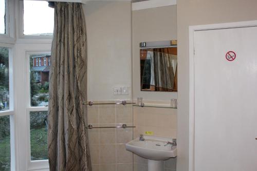 a bathroom with a sink and a mirror at The Darnley Hotel in Ilfracombe