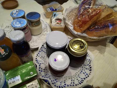 a table with jars of honey and a plate of food at Il Faggio 17 B&B in Artena