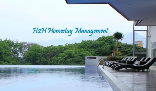 a swimming pool with chairs next to the water at H2H - Reunion House @ Majestic Ipoh 家好月圆 in Ipoh