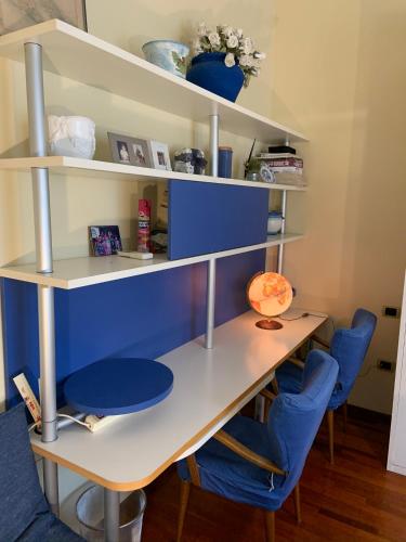 a desk with blue chairs in a room at Casa di Anna in Ravenna