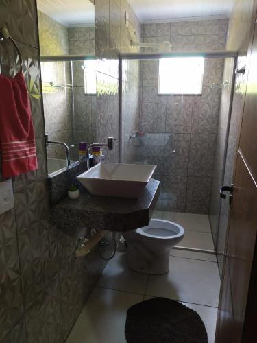 a bathroom with a sink and a toilet at Acomodação chalé entre capitolio e escarpas do lago in Capitólio