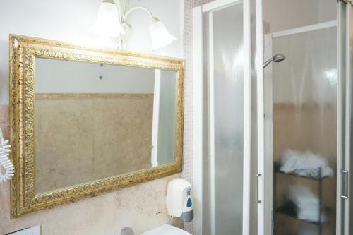a mirror on a wall above a bathroom sink at Corte Canal Venice in Venice