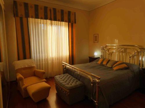 a bedroom with a bed and a chair and a window at Casa di Anna in Ravenna