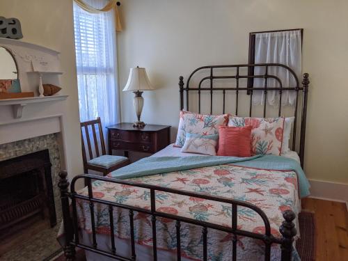 1 dormitorio con 1 cama y chimenea en Surf Song Bed & Breakfast, en Tybee Island