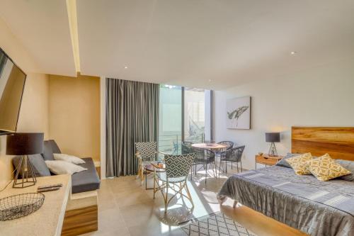 a bedroom with a bed and a living room at Sunset 203 at Riva in Playa del Carmen