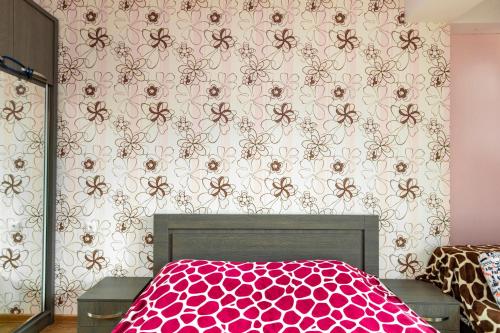 a bedroom with a bed with a pink floral wallpaper at Apart 516 Bobline in Bakuriani