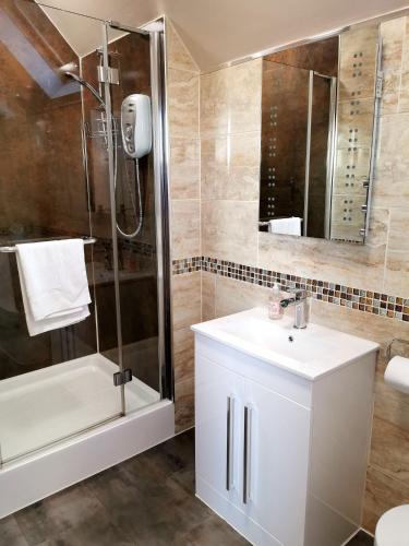 a bathroom with a white sink and a shower at The Knowe Guest House in Callander