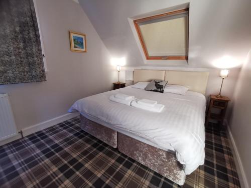 a bedroom with a bed with two towels on it at The Knowe Guest House in Callander