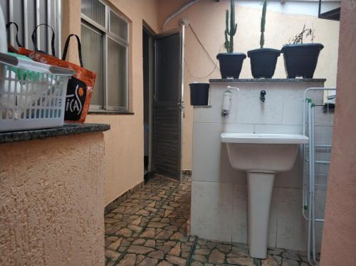 a bathroom with a sink and potted plants on a wall at Casa Dunas Cabo Frio in Cabo Frio