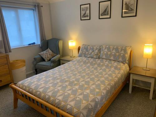 um quarto com uma cama, uma cadeira e uma janela em Ocean em Sidmouth