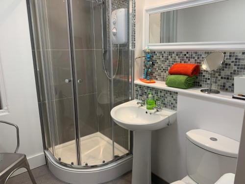 een badkamer met een douche en een wastafel bij Ocean in Sidmouth