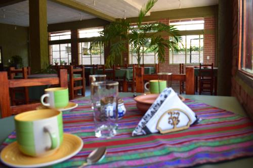 a table with plates and cups on a striped table cloth at Camino a Termas in San Salvador de Jujuy