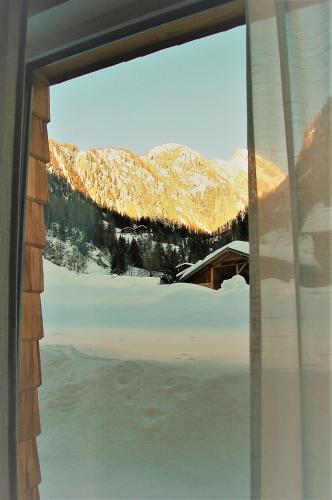 a view of a snowy mountain from a window at Virgentaler Alp in Prägraten am Großvenediger
