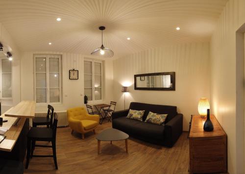 a living room with a couch and a table at Le Charmant Studio Maupassant in Fécamp