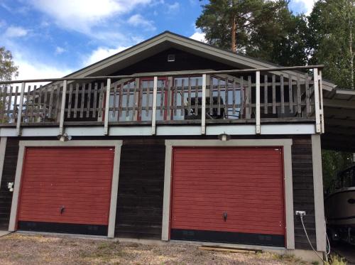a house with two garage doors and a balcony at Hemmet Brommösund Torsö Mariestad in Brommösund