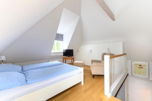 a white bedroom with a bed and a chair at Altstadt Apartments Verden in Verden