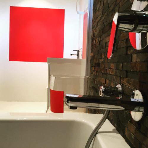a bathroom with a sink and a red wall at Arty Provence, vue, calme et piscine chauffée dans les Alpilles proche St-Rémy-de-Provence in Saint-Étienne-du-Grès