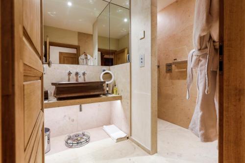 a bathroom with a sink and a shower at Auberge Saint Walfrid Hôtel Restaurant & Spa in Sarreguemines