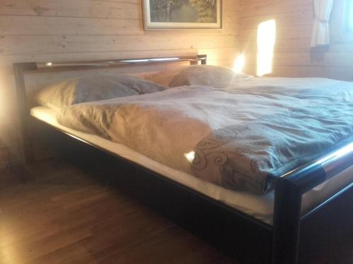 a bed in a bedroom with a wooden wall at Haus Melanie in Hohenau