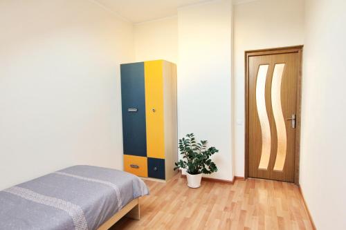 1 dormitorio con 1 cama, armario y planta en Apartments by the lake with fireplace en Trakai
