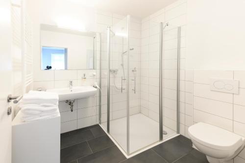 a bathroom with a shower and a toilet and a sink at Altstadt Apartments Verden in Verden