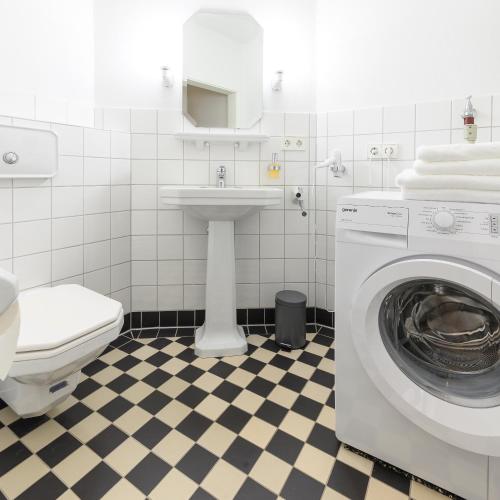 a bathroom with a washing machine and a sink at Altstadt Apartments Verden in Verden