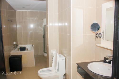 a bathroom with a toilet and a sink at Conference Hotel , Abeokuta in Abeokuta