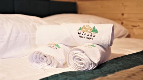 a pile of towels sitting on top of a bed at Wioska Jasia i Małgosi in Izdebnik