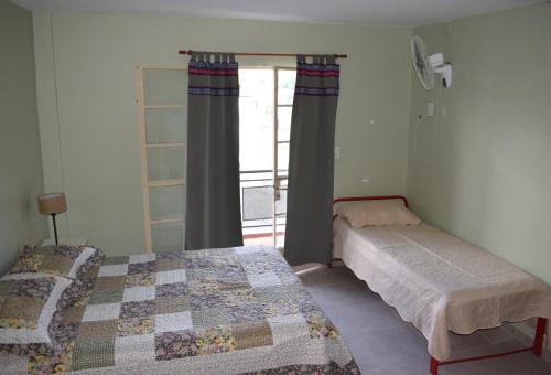 a bedroom with two twin beds and a window at Camino a Termas in San Salvador de Jujuy