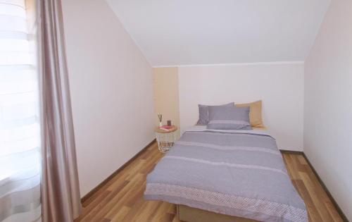 a small bedroom with a bed in the corner at Apartments by the lake with fireplace in Trakai