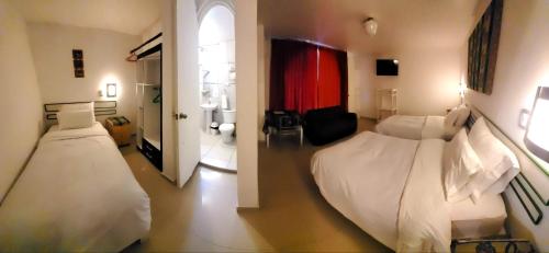 a hotel room with two beds and a bathroom at La Casa de Ana - Peru in Arequipa