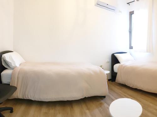 a bedroom with two beds and a table at City Center Rooms in Nazareth